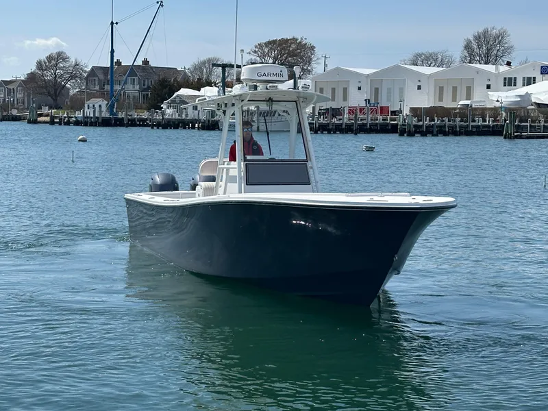 Slide: The Image of 2003 Regulator 26 Center Console boat on calm water near docks. - 5