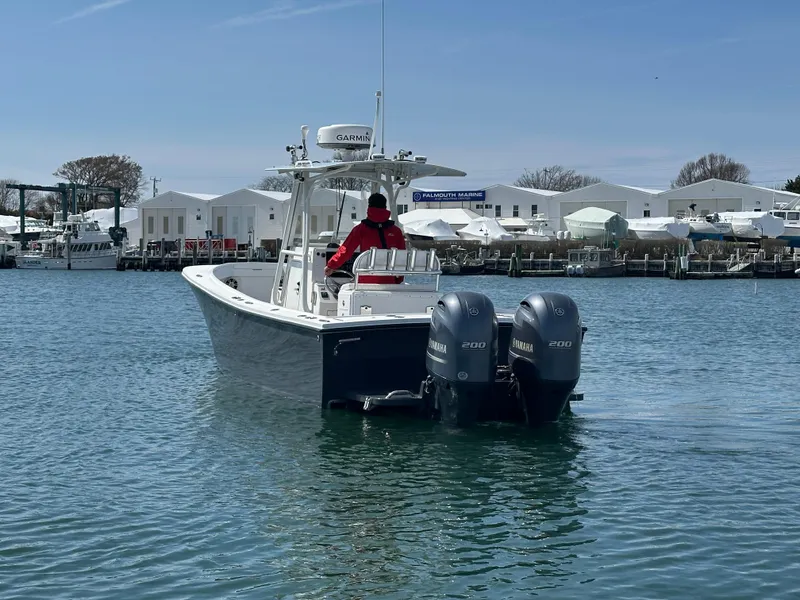 Slide: The Image of 2003 Regulator 26 Center Console boat with twin Yamaha engines on calm water. - 6