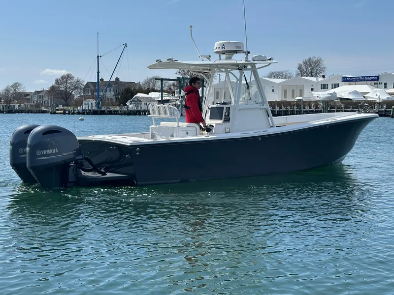 Slide: The Image of 2003 Regulator 26 Center Console boat with Yamaha engines on calm water. - 8