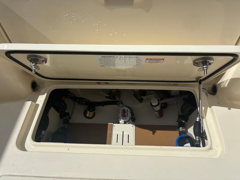 Slide: The Image of 2025 Scout 277 LXF boat storage compartment with open hatch and visible equipment. - 22