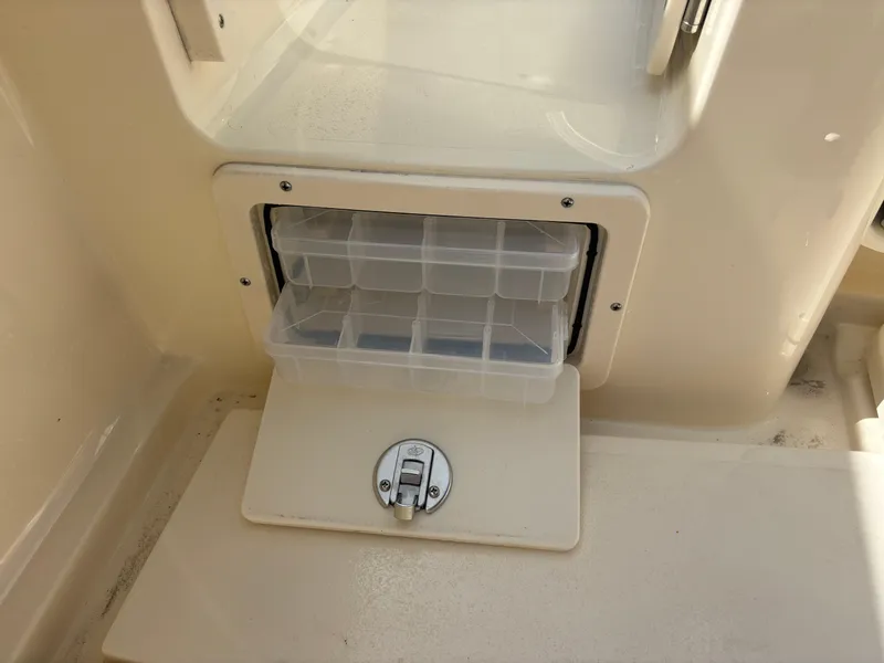 Slide: The Image of 2025 Scout 277 LXF boat storage compartment with clear plastic organizer. - 23