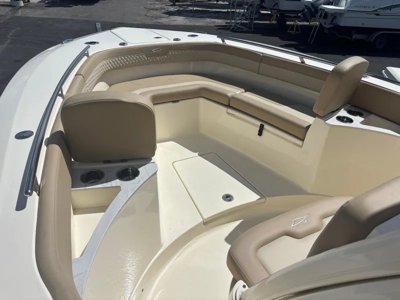 Slide: The Image of 2025 Scout 277 LXF boat interior with beige seating and cup holders. - 9