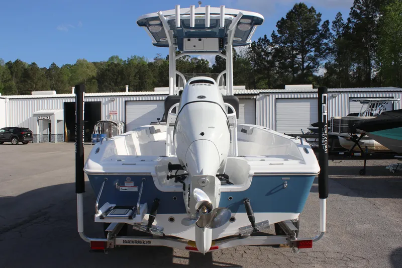 Slide: The Image of 2025 Sea Pro 202 CC boat, rear view, parked outdoors with trees and buildings in background. - 4