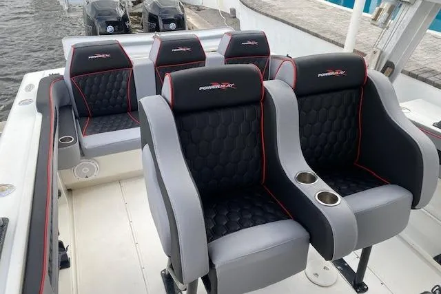 Slide: The Image of 1996 Powerplay Powerboats 33 Sportfish interior with black and gray seating, red accents, and cup holders. - 10