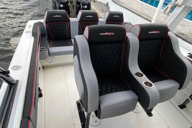 Slide: The Image of 1996 Powerplay Powerboats 33 Sportfish interior with black and gray seating, cup holders, and red accents. - 11
