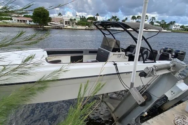 Slide: The Image of 1996 Powerplay Powerboats 33 Sportfish on lift by waterfront homes. - 2