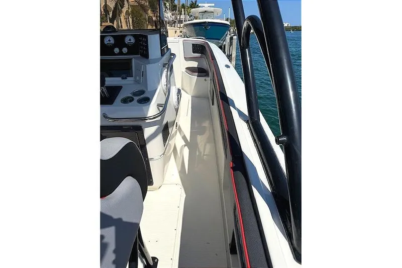 Slide: The Image of 1996 Powerplay Powerboats 33 Sportfish, sleek deck view, docked by clear blue water. - 20