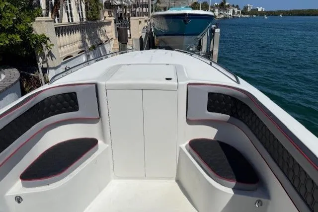 Slide: The Image of 1996 Powerplay Powerboats 33 Sportfish, docked with cushioned seating, overlooking serene waterfront. - 24