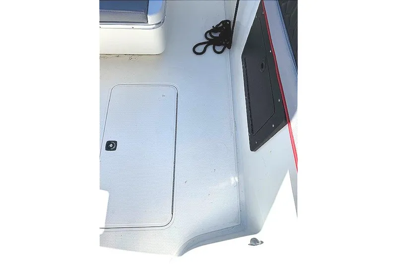 Slide: The Image of 1996 Powerplay Powerboats 33 Sportfish deck with storage hatch and coiled rope. - 29