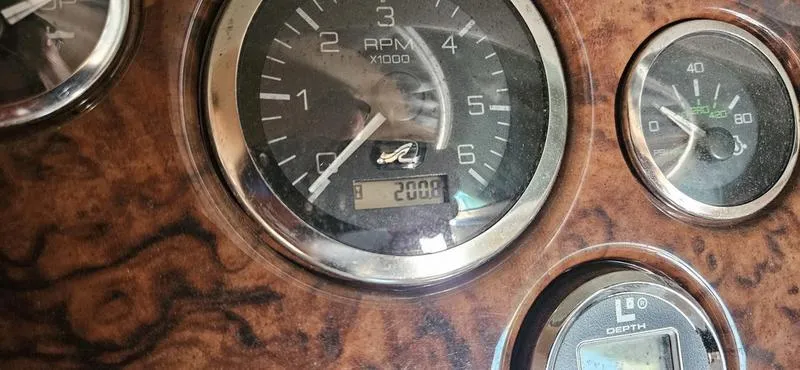 Slide: The Image of Dashboard gauges of a 2003 Sea Ray 220 Sundeck boat, showing RPM and depth. - 3