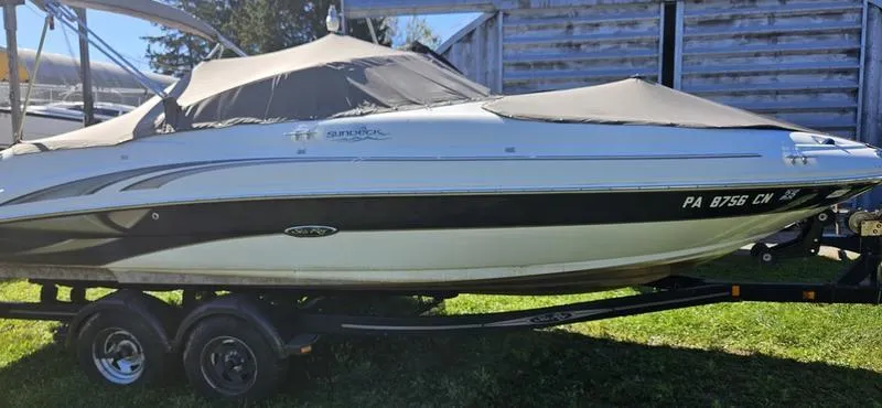 Slide: The Image of 2003 Sea Ray 220 Sundeck boat on trailer, covered and parked outdoors. - 6