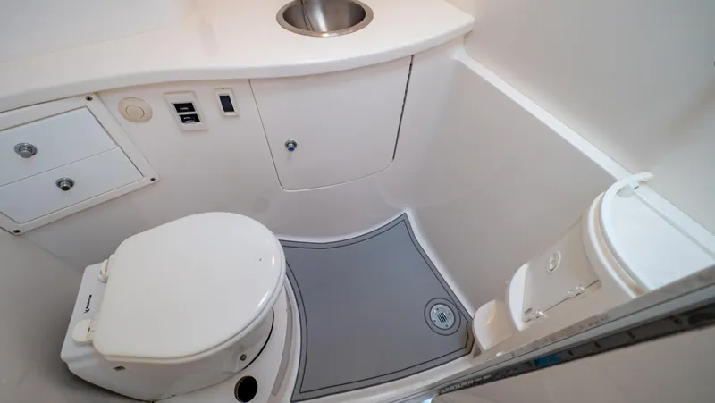 Slide: The Image of 2008 Intrepid 370 Cuddy boat bathroom with toilet, sink, and storage. - 11