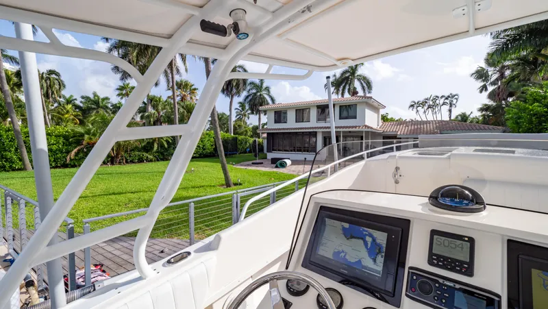 Slide: The Image of 2008 Intrepid 370 Cuddy boat with navigation system, docked near a tropical waterfront home. - 15
