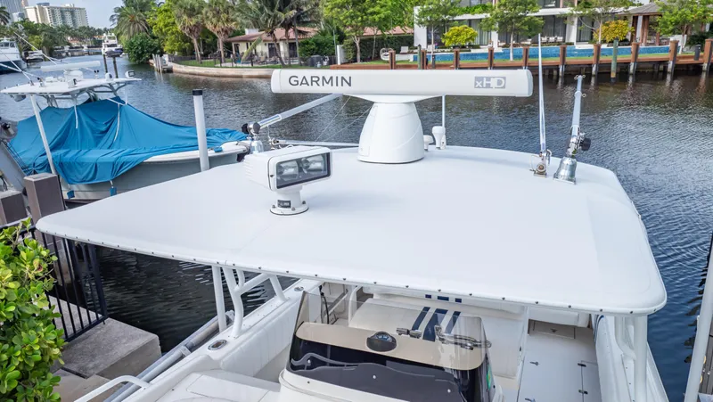 Slide: The Image of 2008 Intrepid 370 Cuddy boat with Garmin radar, docked by a scenic waterfront. - 29