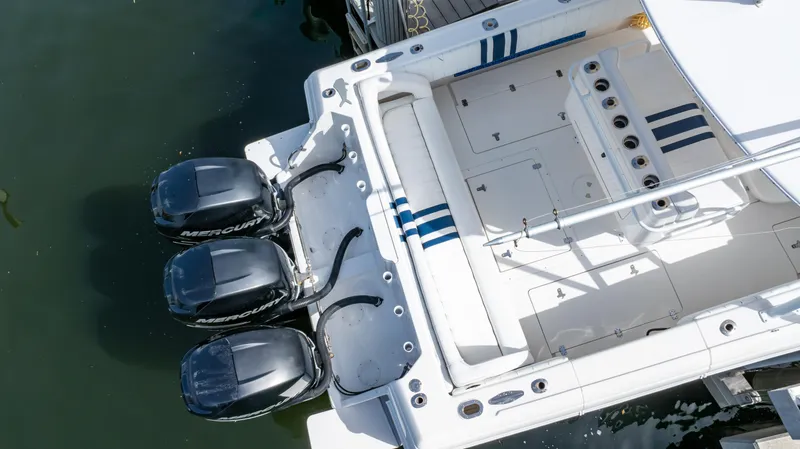 Slide: The Image of 2008 Intrepid 370 Cuddy boat with triple outboard engines, docked in calm water. - 37