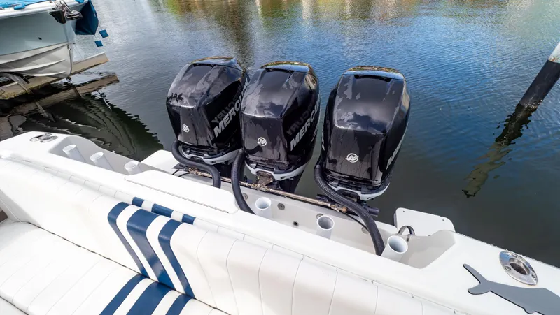 Slide: The Image of Triple Mercury outboard engines on a 2008 Intrepid 370 Cuddy boat, docked by the water. - 38