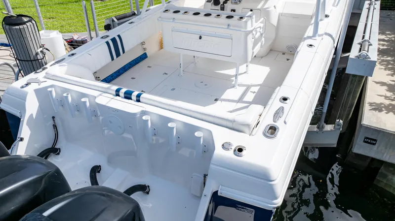 Slide: The Image of 2008 Intrepid 370 Cuddy boat with spacious deck and dual engines docked by the water. - 39