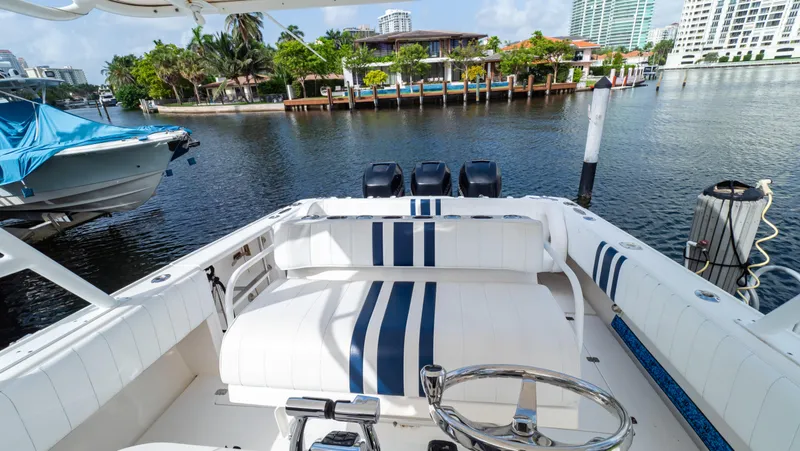 Slide: The Image of 2008 Intrepid 370 Cuddy boat docked in a scenic marina with waterfront views. - 4