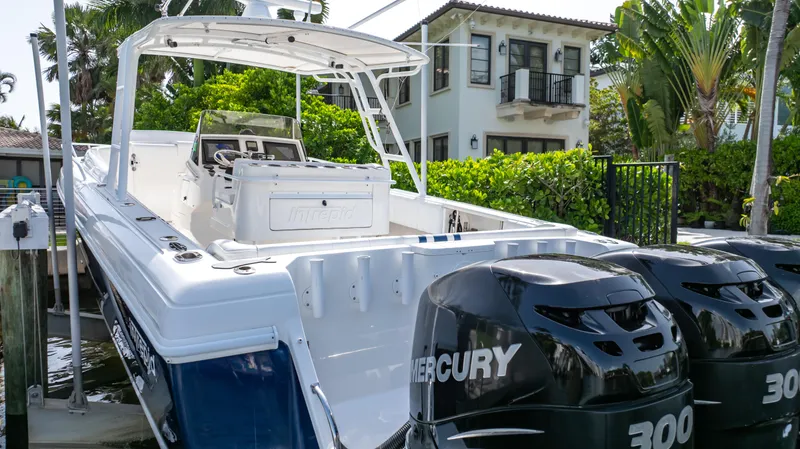 Slide: The Image of 2008 Intrepid 370 Cuddy boat with dual Mercury 300 engines docked near a house. - 40