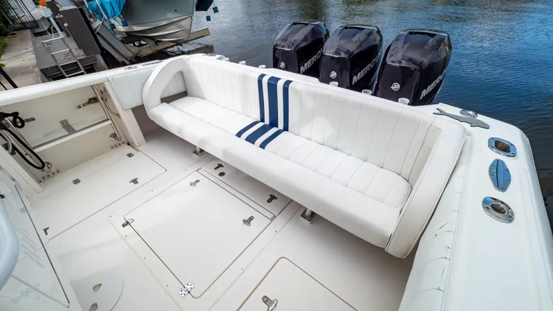 Slide: The Image of 2008 Intrepid 370 Cuddy boat interior with white seating and triple Mercury outboard engines. - 43