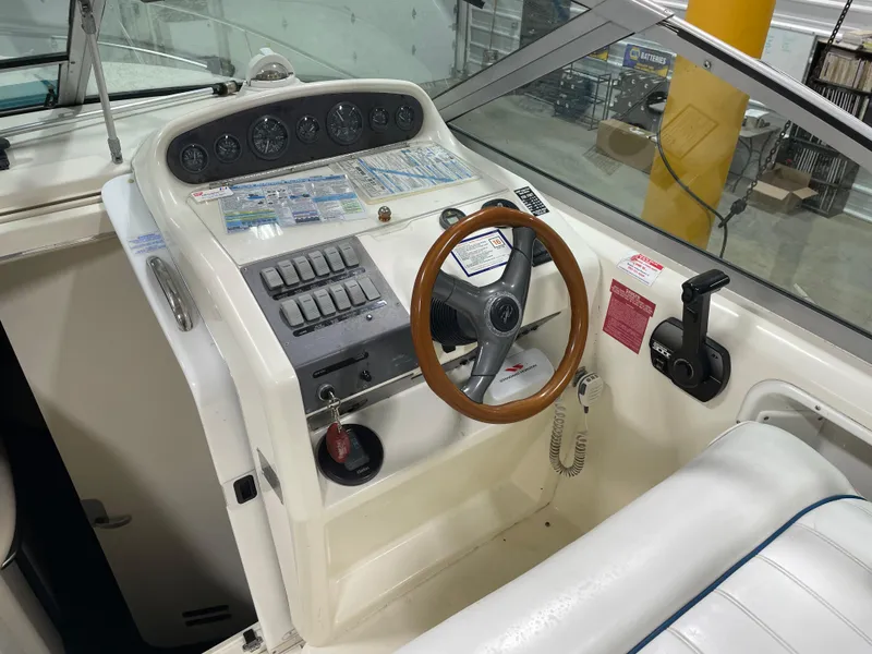 Slide: The Image of 1995 Sea Ray 270 Sundancer helm with wood steering wheel and control panel. - 11