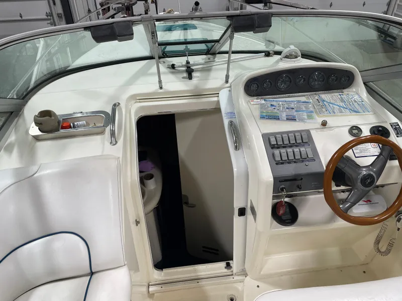 Slide: The Image of 1995 Sea Ray 270 Sundancer boat cockpit with steering wheel and control panel. - 12