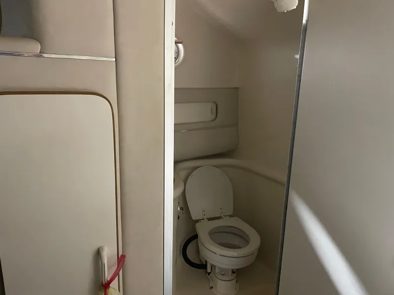 Slide: The Image of 1995 Sea Ray 270 Sundancer boat in a garage, rear view with tarp and trailer. - 5