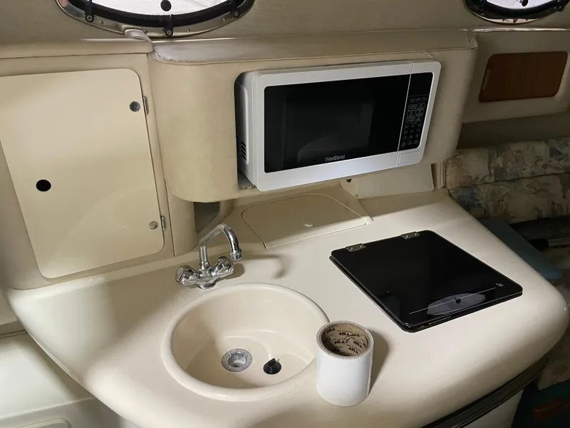 Slide: The Image of 1995 Sea Ray 270 Sundancer boat interior with white seating and steering wheel. - 6