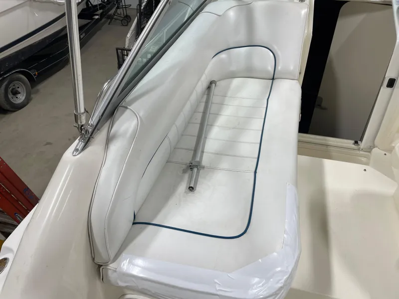 Slide: The Image of 1995 Sea Ray 270 Sundancer boat interior with white cushioned seating. - 9