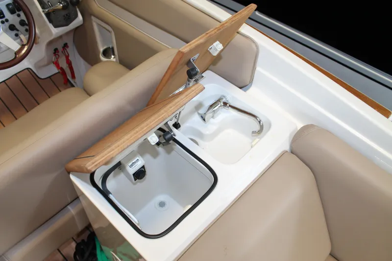 Slide: The Image of 2007 Chris-Craft Launch 28 boat interior with sink and faucet, featuring beige seating. - 14