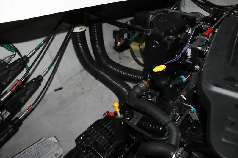 Slide: The Image of Engine compartment of a 2007 Chris-Craft Launch 28 boat, showing hoses and mechanical components. - 18