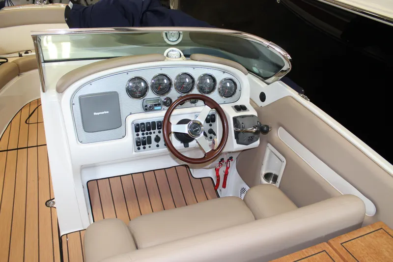 Slide: The Image of 2007 Chris-Craft Launch 28 boat cockpit with wooden steering wheel and dashboard controls. - 25