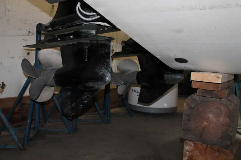 Slide: The Image of 2007 Chris-Craft Launch 28 boat propellers and hull in storage, supported by stands and blocks. - 31