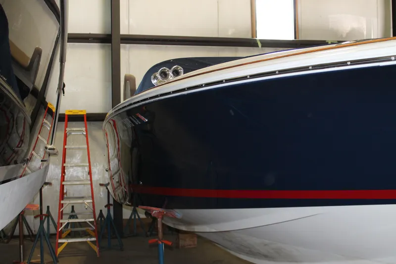 Slide: The Image of 2007 Chris-Craft Launch 28 boat in storage, blue hull with red stripe, indoor setting. - 4