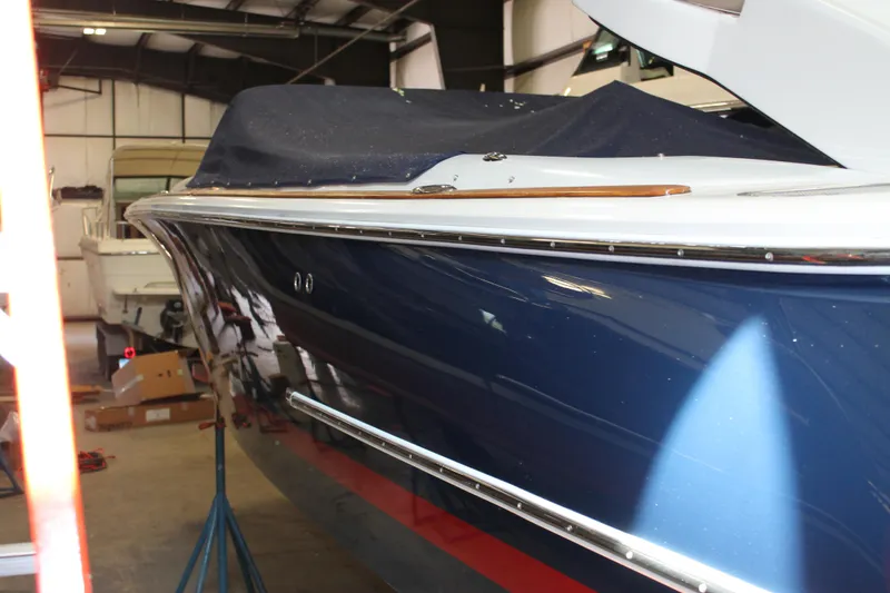 Slide: The Image of 2007 Chris-Craft Launch 28 boat in storage, blue hull, covered, indoor setting. - 7
