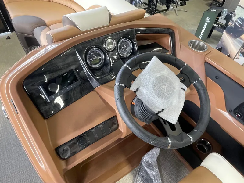 Slide: The Image of 2025 Tahoe Pontoon 2185 LTZ dashboard with steering wheel and gauges, featuring brown interior. - 11