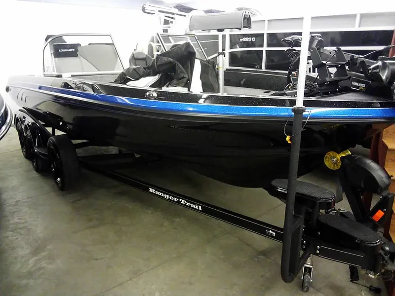 The Image of 2024 Ranger 622FS Pro DC boat on trailer, black with blue accents, in showroom. - 0