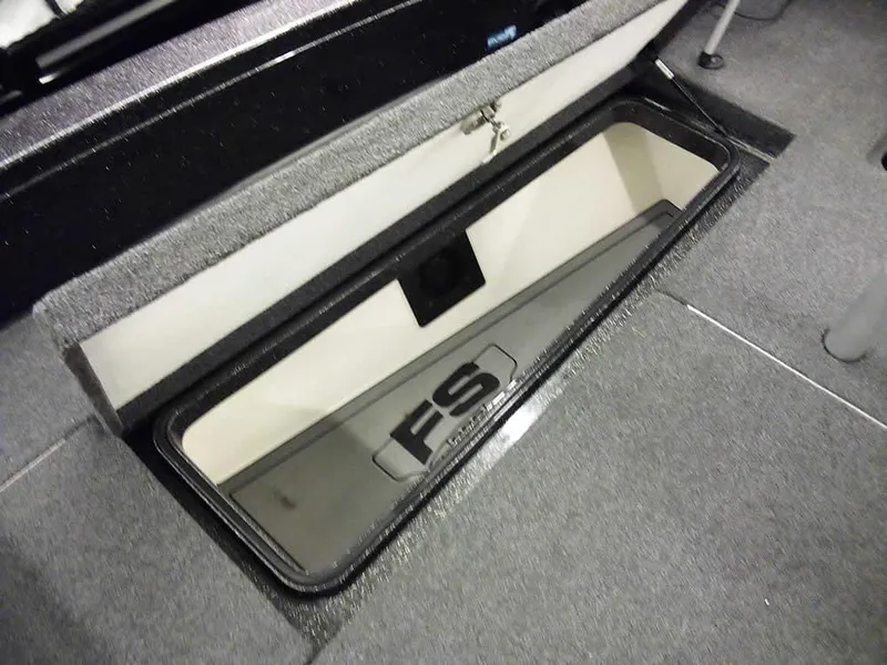 Slide: The Image of 2024 Ranger 622FS Pro DC boat storage compartment with carpeted interior and secure latch. - 16