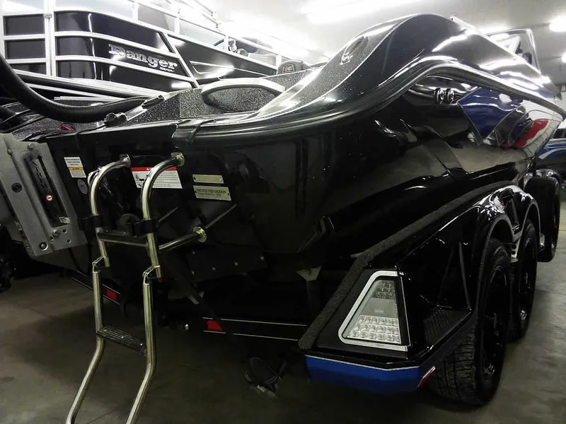 Slide: The Image of 2024 Ranger 622FS Pro DC boat, rear view, in showroom with ladder and sleek black design. - 6