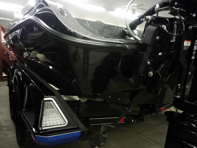 Slide: The Image of 2024 Ranger 622FS Pro DC boat, rear view, black finish, in a garage setting. - 8