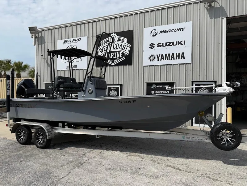 Slide: The Image of 2024 Blazer 2400 boat on trailer at West Coast Marine dealership. - 1