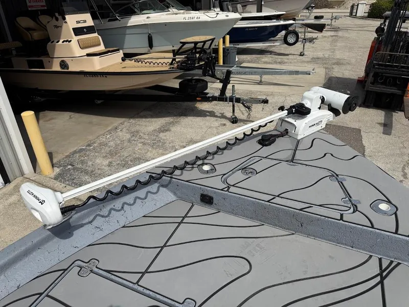 Slide: The Image of 2024 Blazer 2400 boat with trolling motor, docked near other boats. - 18