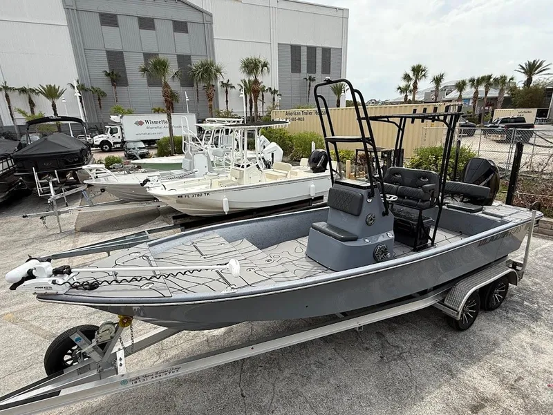 Slide: The Image of 2024 Blazer 2400 boat on trailer, parked outdoors near other boats. - 21