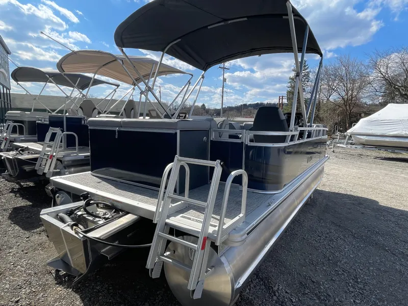 Slide: The Image of 2025 Tahoe Pontoon 1980 Sport Cruise boat with canopy, parked outdoors under a blue sky. - 4