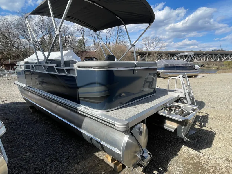 Slide: The Image of 2025 Tahoe Pontoon 1980 Sport Cruise boat with canopy, parked outdoors on a sunny day. - 6