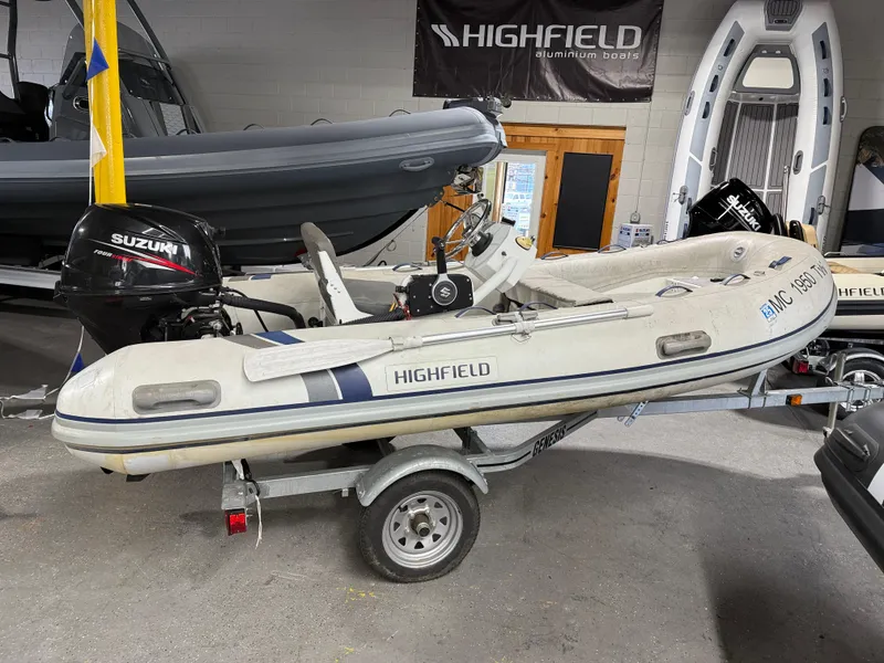 Slide: The Image of 2016 Highfield Classic 360 FCT inflatable boat on trailer, displayed indoors. - 0