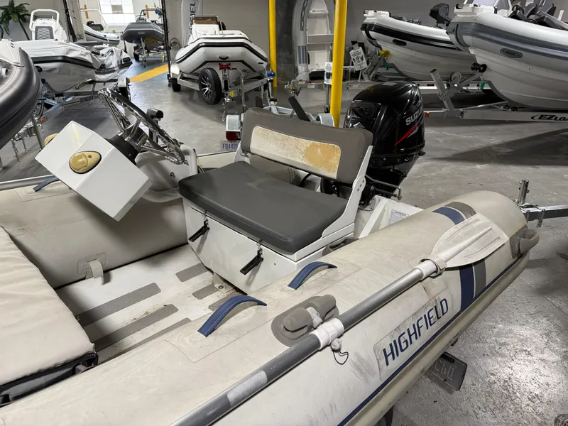 Slide: The Image of 2016 Highfield Classic 360 FCT inflatable boat with seating and oars in a showroom. - 2