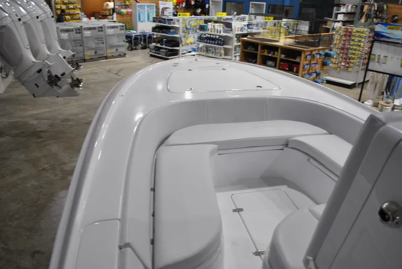 Slide: The Image of 2025 Contender 25 Bay boat interior in a showroom with various products displayed. - 11