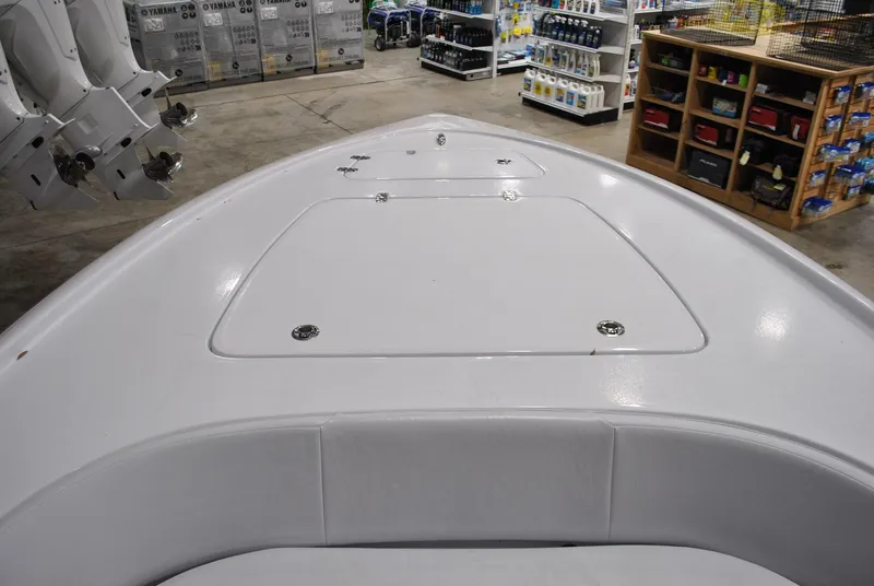 Slide: The Image of 2025 Contender 25 Bay boat deck in showroom, featuring storage compartments and sleek design. - 12