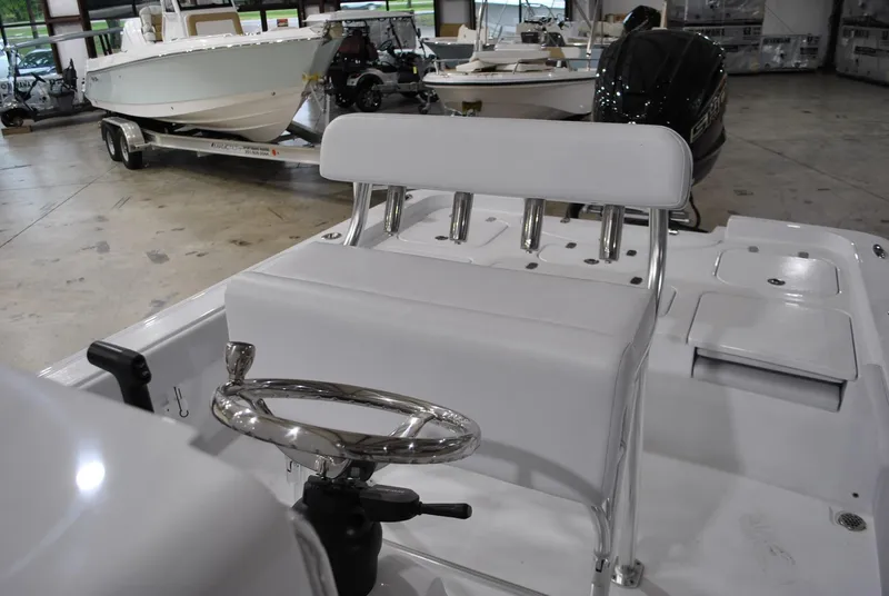 Slide: The Image of 2025 Contender 25 Bay boat interior with steering wheel and seating in a showroom. - 16